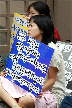 이랜드 비정규직 노동자들과 연대하기 위해 온 한국기독청년학생연합회 회원들이 피켓을 들고 있다. 